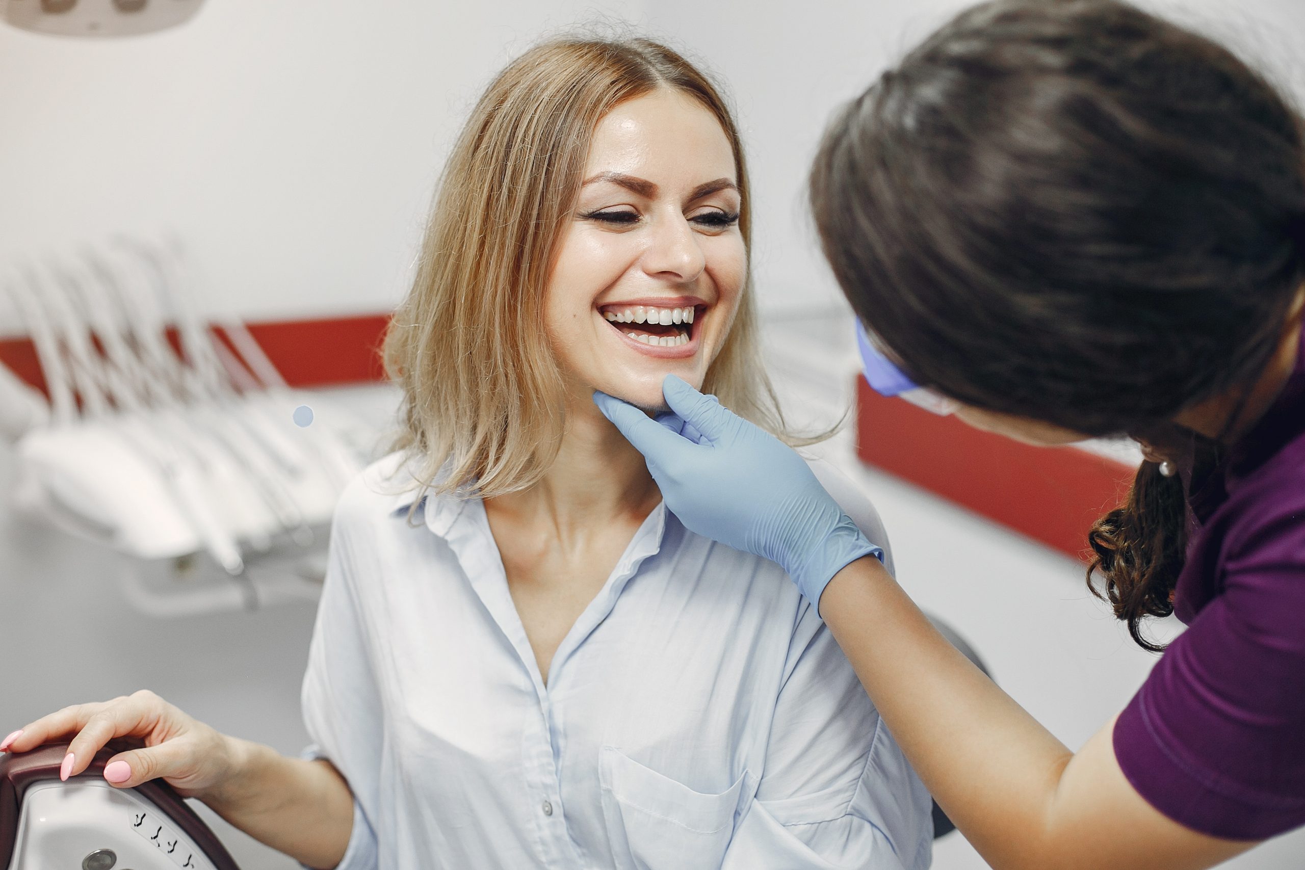 Beautiful lady in the dentist's office. Woman in a purple uniform